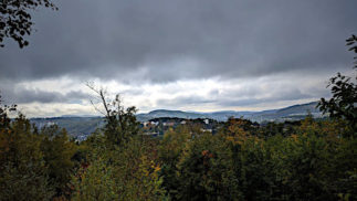 Blick vom Häusling auf den dunkel bewölkten Himmel und Siegen.